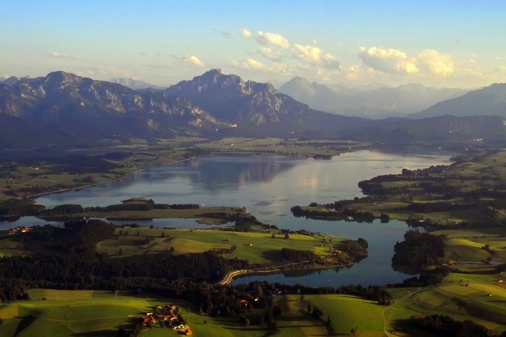 Der Forggensee aus der Luft. Im Hintergrund Schloss Neuschwanstein. © Foto von pixabay